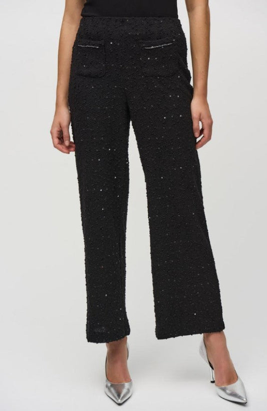 Black textured pants worn by a person on a white background