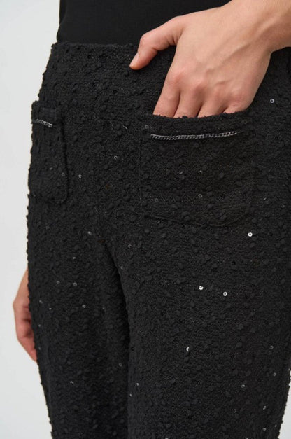 Black textured pants with sequin details on a white background