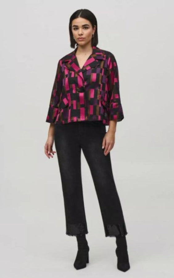 Woman wearing a patterned jacket and black pants on a white background