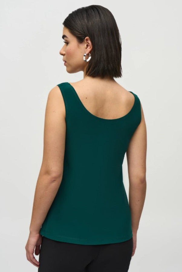 Woman wearing a green tank top on a white background