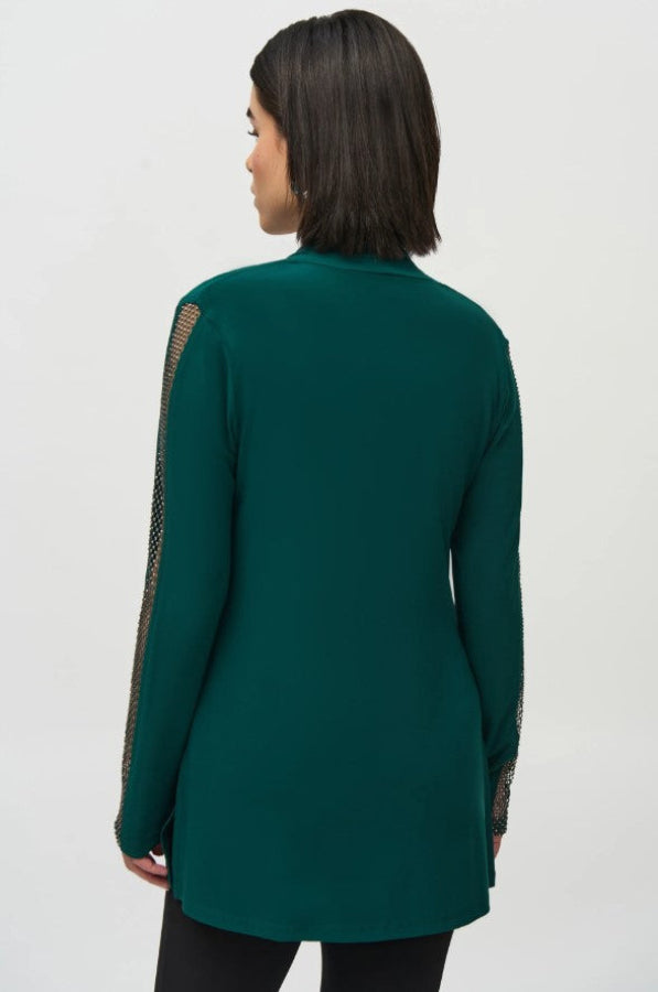 Green long-sleeve top worn by a person on a white background