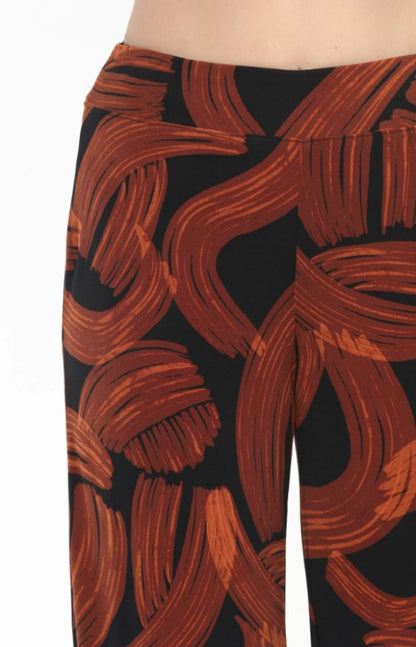Black pants with large orange abstract brushstroke pattern