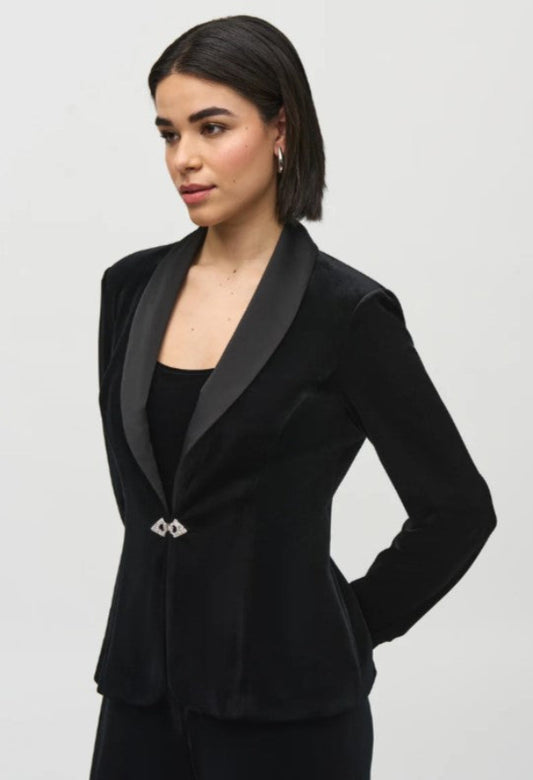 Woman wearing a black tuxedo jacket on a light gray background