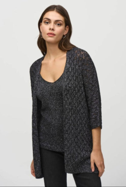 Woman wearing a dark patterned cardigan over a plain top on a light gray background