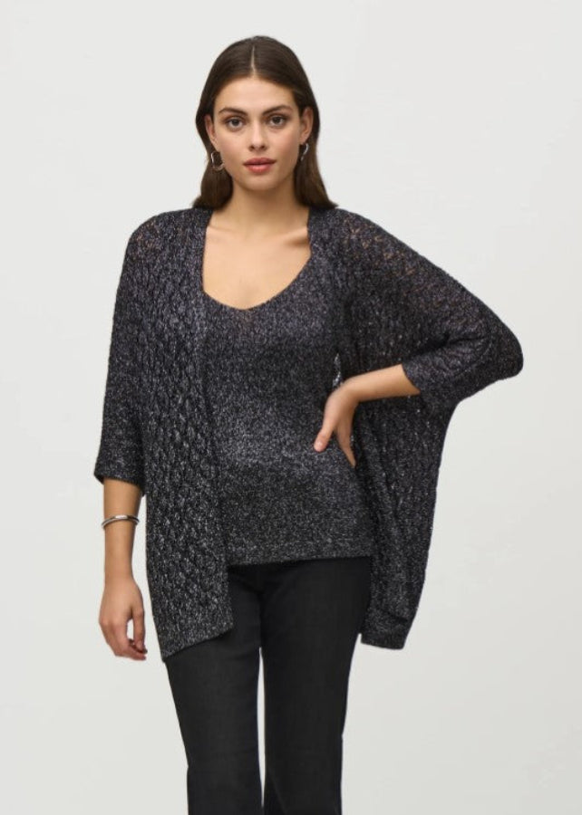 Woman wearing a black and gray patterned cardigan over a top on a white background