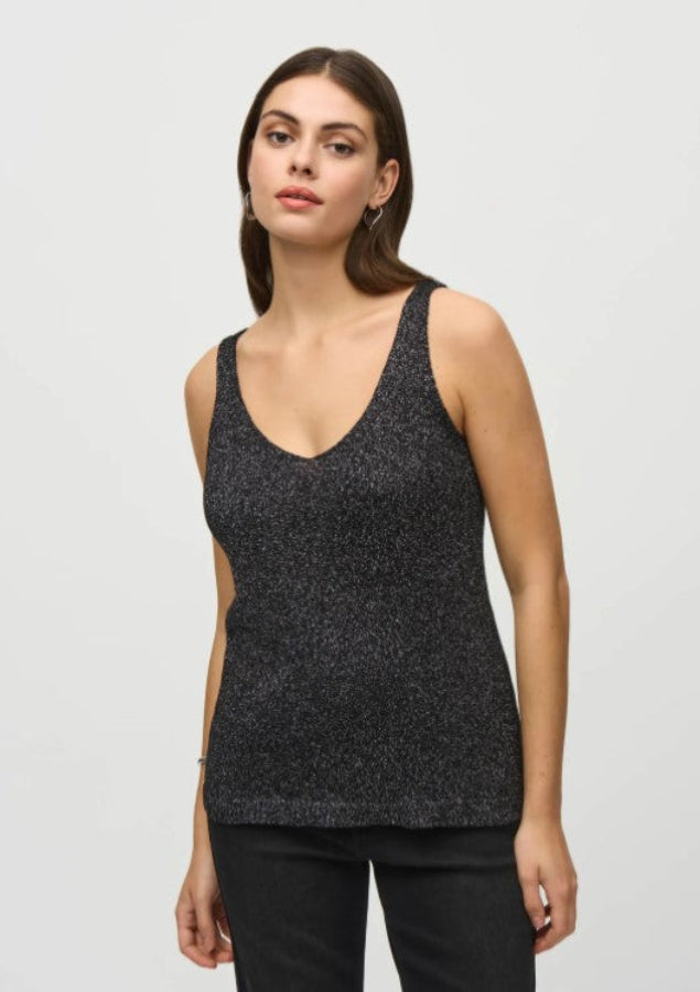 Woman wearing a black tank top against a light gray background