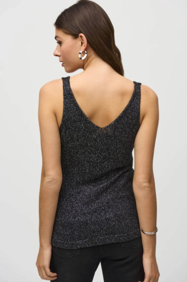 Woman wearing a black sparkly tank top on a light gray background