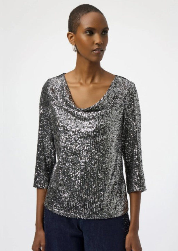 Woman wearing a silver sequin top on a white background