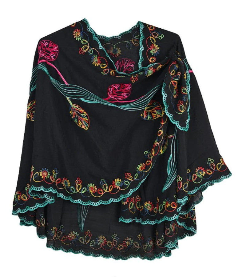 Black cape with colorful floral embroidery on a white background
